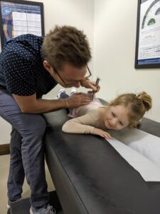 Pediatric chiropractor in Wall Township NJ gently checking baby’s neck alignment.