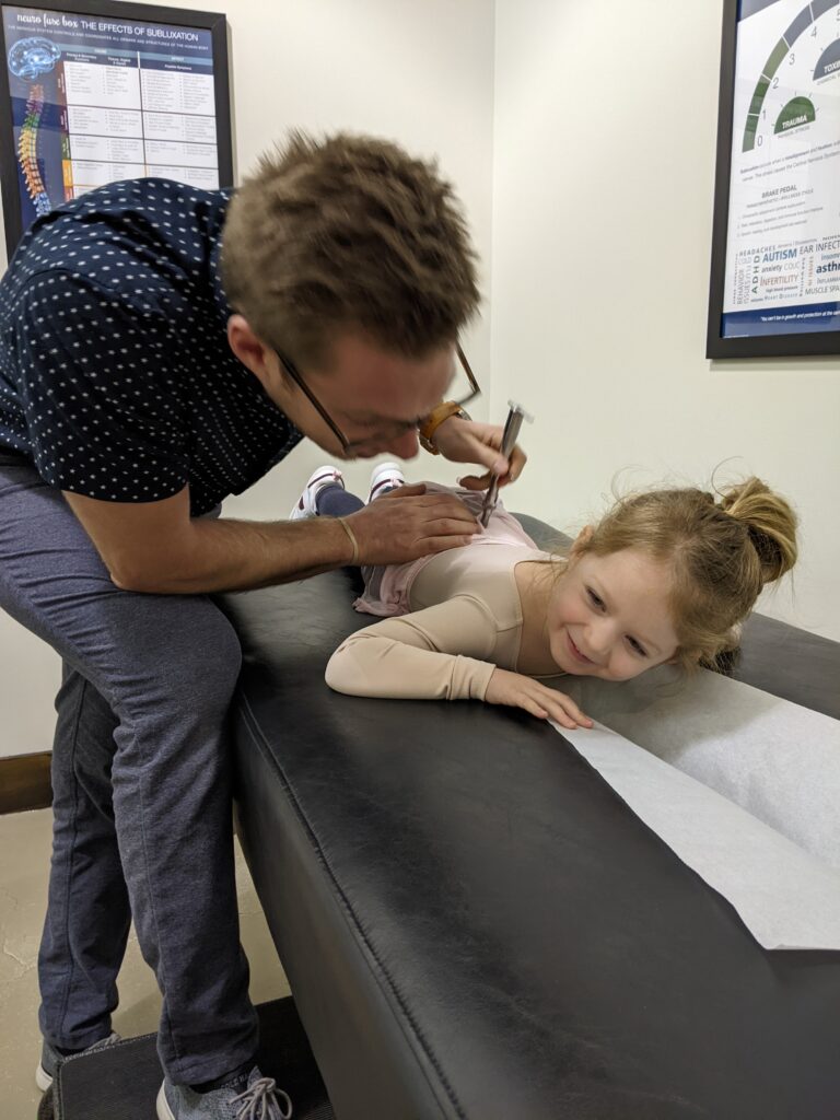 Pediatric chiropractor in Wall Township NJ gently checking baby’s neck alignment.