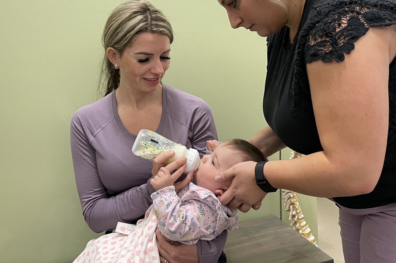 Watching a baby latch onto a bottle during a feeding assessment