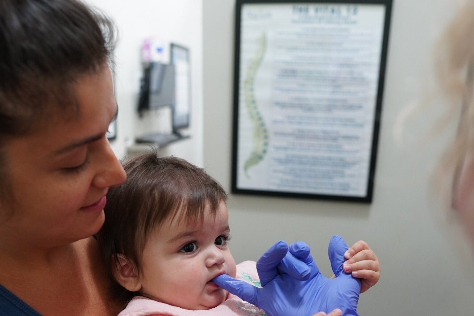 Gloved oral assessment of an infant for tongue tie and oral tension at Absolute Chiropractic